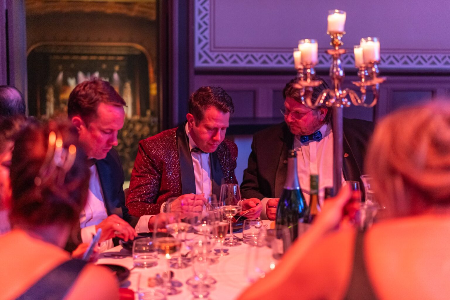 Gasten aan tafel tijdens het galadiner van het Hofbal, met kandelaars en kaarslicht
